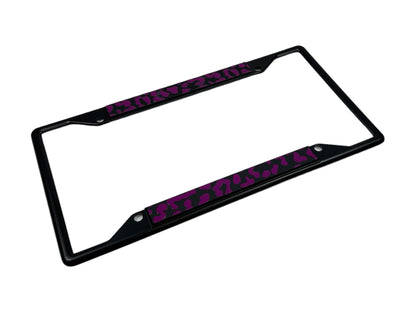 a black license plate frame with pink letters