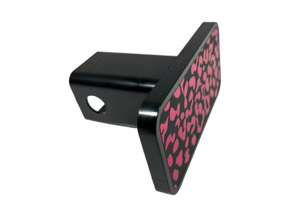 a black and pink object with hearts on it