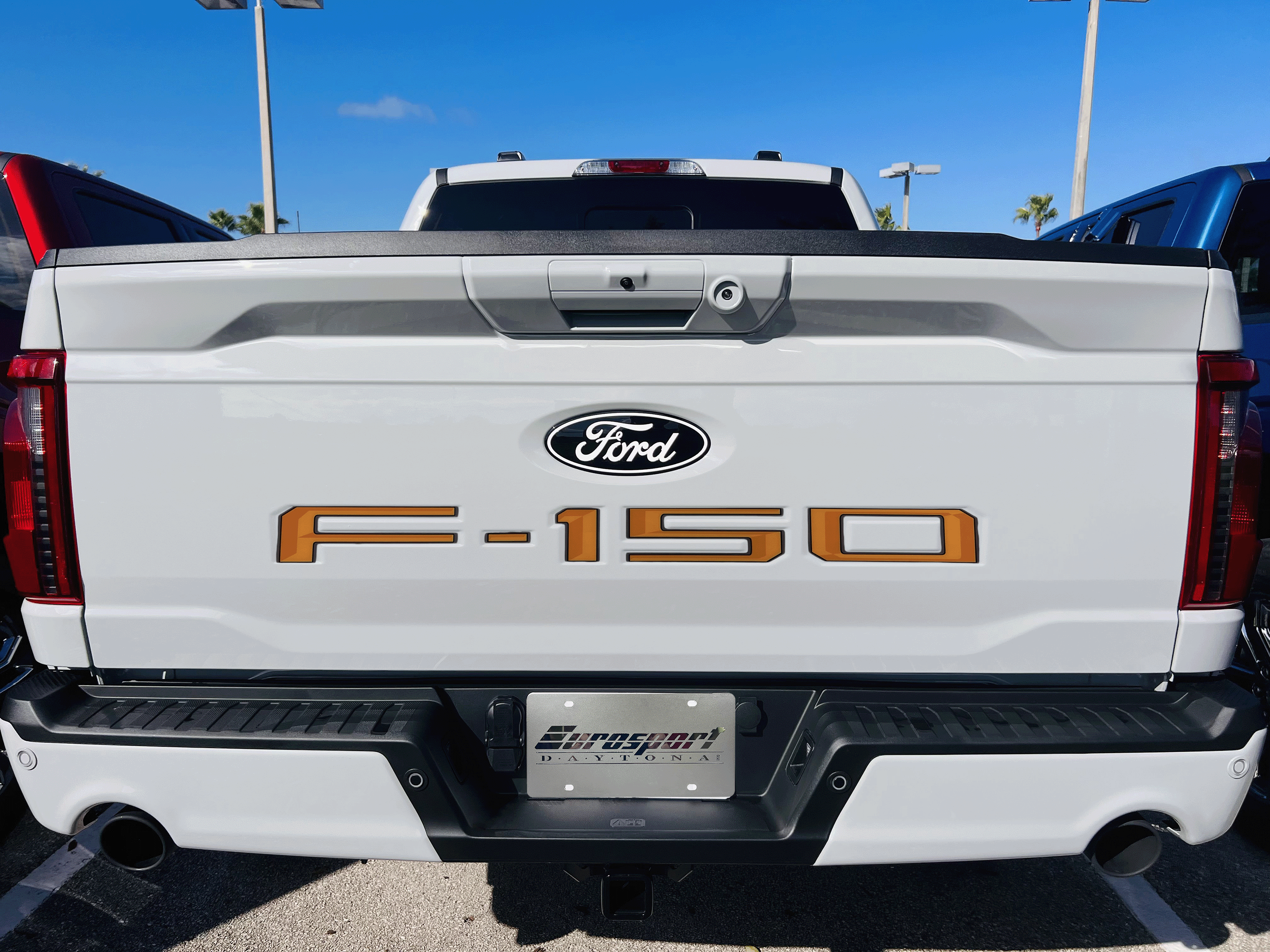 a white ford f - 150 pickup truck parked in a lot